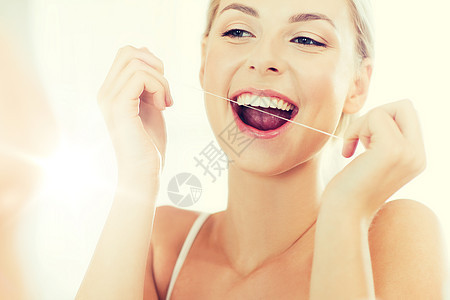 保健,牙科卫生,人美容微笑的轻妇女用牙线清洁牙齿,并家里的浴室看镜子浴室用牙线清洁牙齿的女人图片