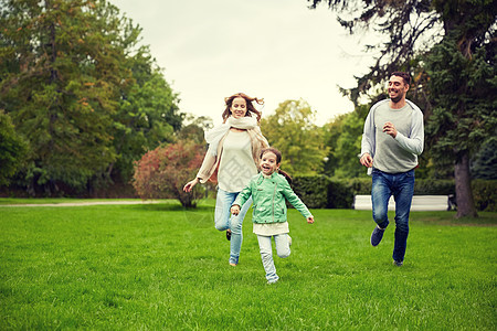 家庭亲子休闲人的快乐的母亲父亲小女孩夏天的公园里跑步玩接球游戏快乐的家人夏天的公园散步图片