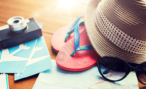 暑假,旅游物品旅行,拖鞋,帽子相机与飞机票家里的木桌上旅行,帽子相机图片