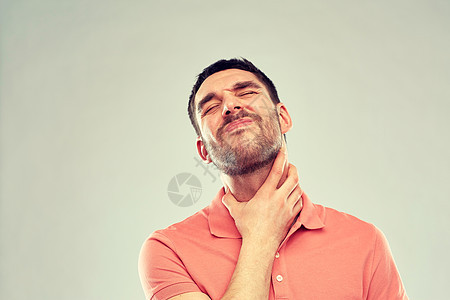喉咙疼痛的灰色背景男人摸脖子图片
