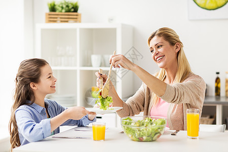 健康饮食,家庭人的快乐的母亲女儿家里厨房吃蔬菜沙拉快乐的家庭家里厨房吃沙拉快乐的家庭家里厨房吃沙拉图片