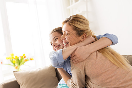 人们家庭的快乐的微笑女孩母亲拥抱沙发上家幸福微笑的家人家里沙发上拥抱幸福微笑的家人家里沙发上拥抱图片
