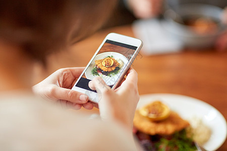 食物,新北欧美食,技术,饮食人的女人与智能手机拍摄包鱼片与酒石酱烤箱烤甜菜根番茄沙拉餐厅智能手机的女人咖啡背景图片