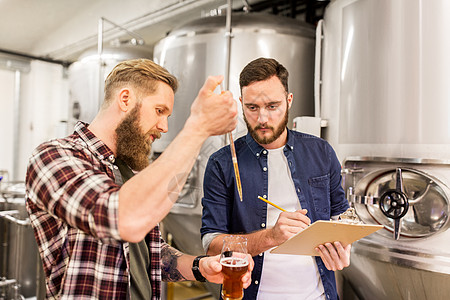 酒精生产,制造,商业人的男人与吸管剪贴板测试工艺啤酒啤酒厂啤酒厂用吸管测试工艺啤酒的男人啤酒厂用吸管测试图片