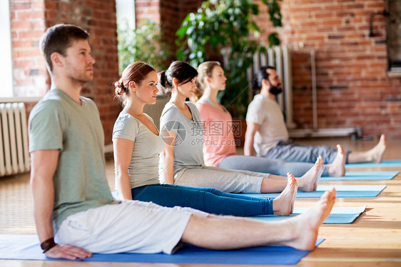 健身,运动健康的生活方式群人瑜伽坐着的工作人员工作室的垫子上摆姿势群瑜伽的人工作室摆姿势群瑜伽的图片