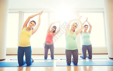 怀孕,运动,健身,人健康的生活方式群快乐的孕妇健身房的垫子上锻炼快乐的孕妇健身房的垫子上锻炼快乐的孕妇健图片