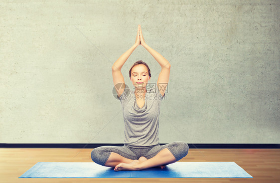健身,运动,人健康的生活方式妇女瑜伽冥想莲花姿势垫子上的健身房背景女人垫子上莲花姿势的瑜伽冥想图片