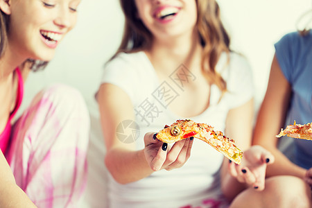 友谊,人,睡衣派垃圾食品亲密的快乐朋友十几岁的女孩家里吃比萨饼快乐的朋友十几岁的女孩家吃披萨图片