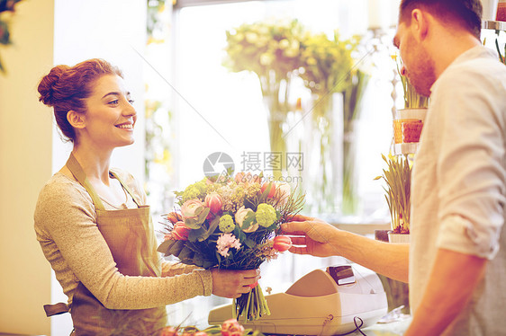 人,购物,销售,花卉消费观念快乐微笑的花店妇女为男人顾客制作花花店微笑的花店男女图片