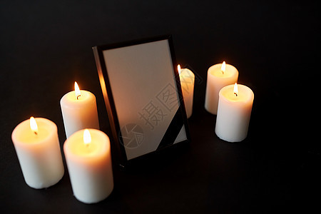 葬礼哀悼相框与黑色丝带燃烧蜡烛黑暗的背景带黑色丧带蜡烛的相框图片