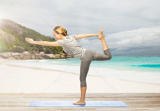健身,运动健康的生活方式妇女瑜伽的主舞姿势垫子上异国情调的热带海滩背景瑜伽的女人,海滩上的舞蹈大师图片