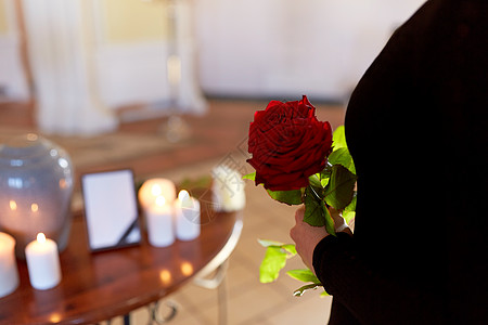 火葬,人哀悼的女人带着红玫瑰教堂葬礼上的骨灰盒葬礼上着玫瑰火葬瓮的女人图片