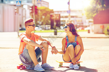 暑假,极限运动人们的快乐的青少夫妇与短现代巡洋舰滑板城市街道轻夫妇城市街道上滑板图片