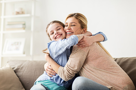 人们家庭的快乐的微笑女孩母亲拥抱沙发上家幸福微笑的家人家里沙发上拥抱图片