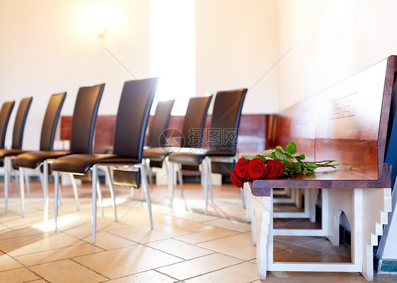 葬礼哀悼教堂长凳上的红玫瑰教堂葬礼上长凳上的红玫瑰图片