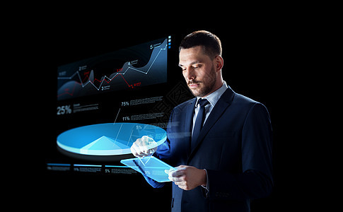 商业,人未来的技术商人适合与透明平板电脑虚拟饼图投影黑色背景拥平板电脑虚拟饼图的商人图片