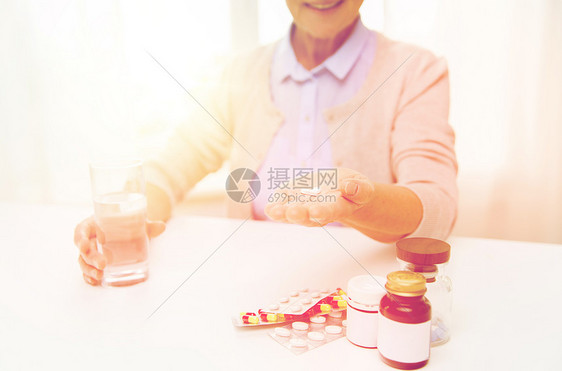 龄,医学,保健人的亲密的快乐老妇女与药丸璃水家里快乐的老妇女家喝水吃药图片