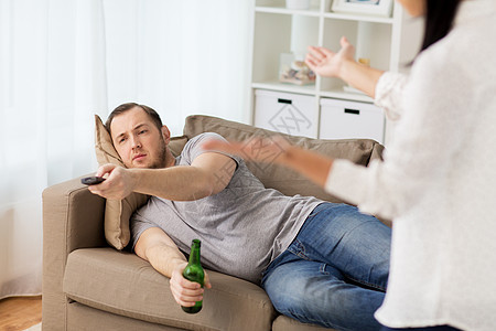 人,关系困难,冲突家庭观念愤怒的女人男人家里喝啤酒看电视夫妇家里吵架图片