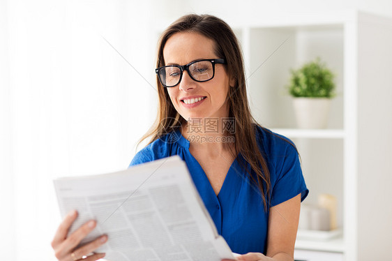 商业,人民大众媒体的快乐的微笑女人眼镜阅读报纸办公室快乐的女人戴着眼镜办公室看报纸图片