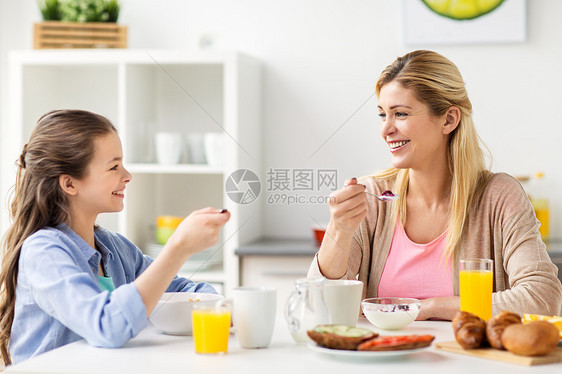 健康饮食,家庭人的快乐的母亲女儿家里的厨房吃早餐幸福的家庭家里的厨房吃早餐图片