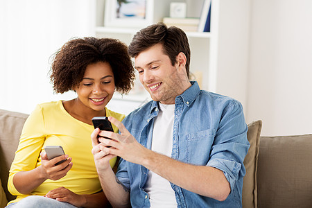人,技术通信幸福的夫妇与智能手机网络短信家里家里智能手机的幸福夫妇图片