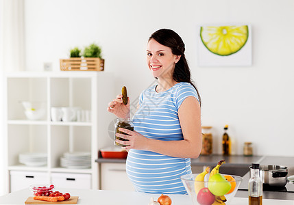 怀孕,营养人们的快乐的孕妇家里厨房吃泡菜孕妇家里厨房吃泡菜图片