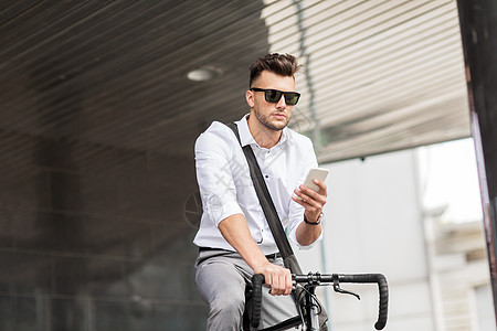生活方式,交通,沟通人的轻人骑自行车智能手机城市街道城市街道上自行车智能手机的人图片