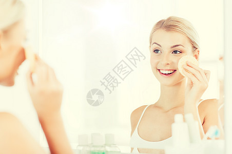 美容,护肤人的微笑的轻女人洗她的脸与部清洁海绵浴室轻女子浴室用海绵洗脸背景图片