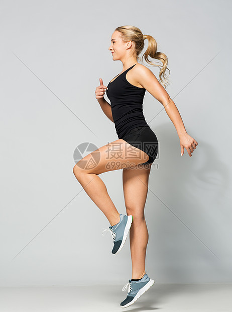 运动,健身人的轻的女人穿着黑色运动服健身房跳跃穿着黑色运动服的轻女子跳跃图片
