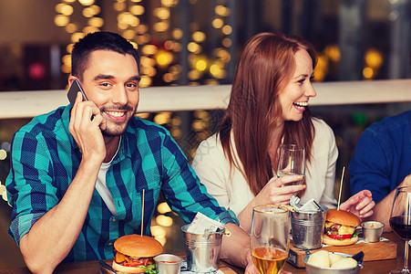 休闲,技术,生活方式人们的快乐的人与智能手机朋友餐厅就餐餐厅智能手机朋友的男人图片