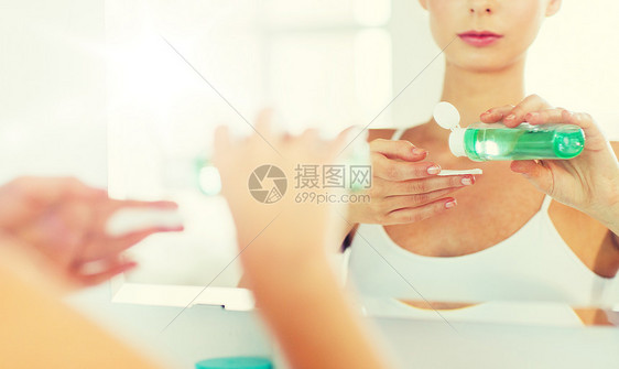 美容,皮肤护理人的近距离的轻妇女应用乳液棉花盘,以洗她的脸浴室轻的女人浴室洗洗脸图片