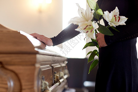 人们哀悼的女人带着白色百合花棺材教堂的葬礼上葬礼上百合花棺材的女人图片