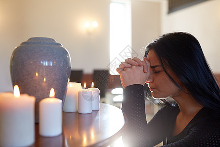 人们哀悼的悲伤的女人,教堂的葬礼上,着骨灰盒蜡烛祈祷悲伤的女人带着骨灰盒教堂祈祷图片