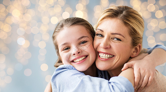 母亲节,人们家庭的快乐的微笑女孩与母亲拥抱灯光背景女孩母亲拥抱的幸福家庭图片