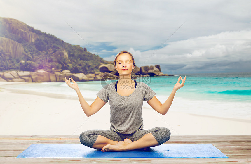 健身,人们健康的生活方式妇女异国情调的热带海滩背景的垫子上莲花姿势的瑜伽冥想海滩上莲花姿势瑜伽冥想的女人图片