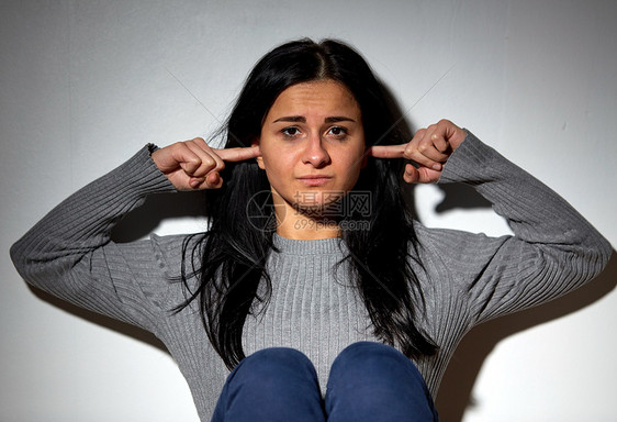 人压力的快乐的女人用手指闭着耳朵幸的女人用手指闭着耳朵图片