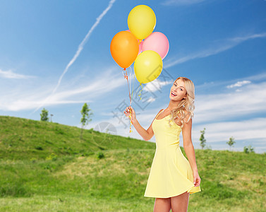 人们,暑假聚会的快乐的轻女人十几岁的女孩穿着粉红色的衣服,蓝天绿色的田野背景上氦气球夏天带氦气气球的快乐女图片