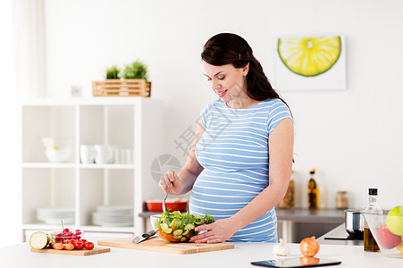 孕妇在厨房煮蔬菜沙拉高清图片