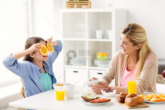 健康饮食,家庭人的快乐的母亲女儿家里的厨房吃早餐幸福的家庭家里的厨房吃早餐图片