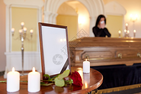 人们哀悼的相框与黑色丝带,蜡烛妇女哭棺材附近的葬礼教堂相框葬礼上棺材上哭泣的女人图片
