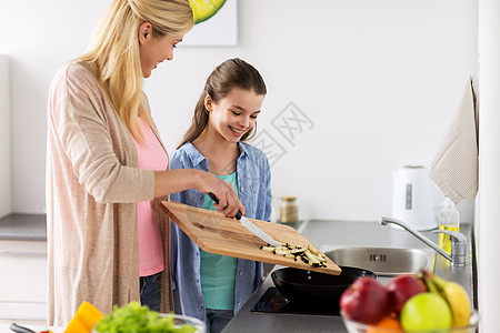 健康饮食,家庭人的快乐的母亲女儿饭油炸食品晚餐家里厨房幸福的家庭家里厨房饭图片