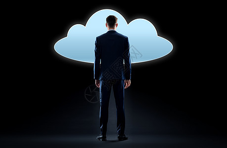 商业,人技术商人穿着西装,黑色背景下看虚拟云全息图商人看虚拟云全息图图片