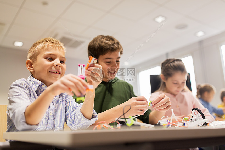 快乐的孩子在学校的课上建造机器人图片