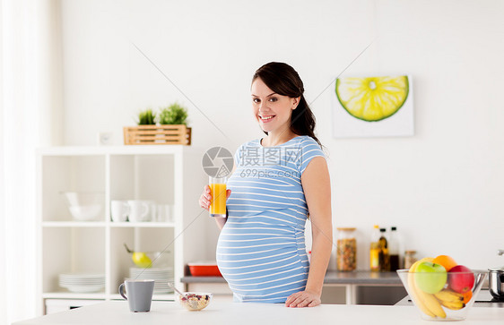 怀孕,人们健康的饮食观念快乐的孕妇喝杯橙汁,家里的厨房吃早餐快乐的孕妇家吃早餐图片