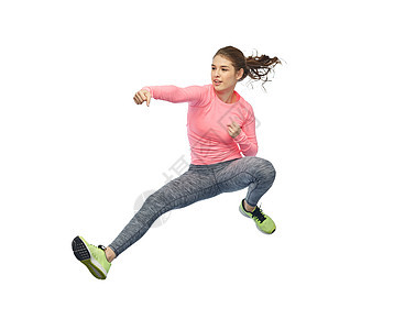 运动,健身,运动人的快乐的轻女人空中跳跃,白色背景上的战斗姿势快乐运动的轻女人跳战斗姿势图片