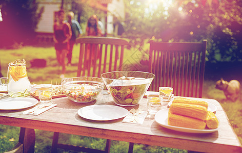 假期,饮食,用餐时间食物人们来提供桌子与晚餐夏季花园聚会人们夏天的花园里带着食物来吃饭图片