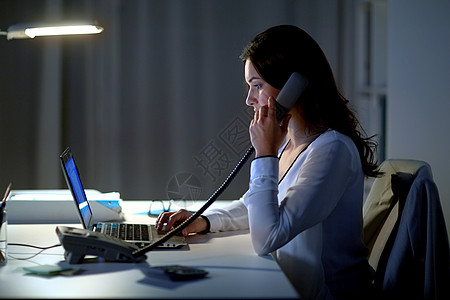 商务,过度工作,截止日期人的女人笔记本电脑上打字夜间办公室打电话笔记本电脑的女人夜间办公室打电话图片
