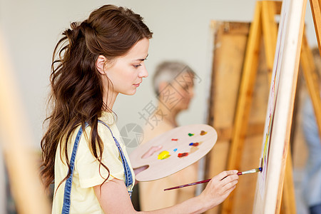 艺术学校,创造力人的学生女孩轻的女艺术家与画架,调色板油漆画笔工作室艺术学校画架的学生女孩图片