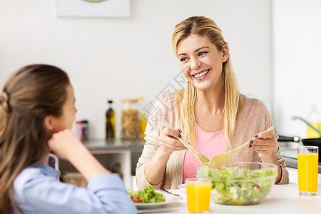 健康饮食,家庭人的快乐的母亲女儿家里厨房吃蔬菜沙拉快乐的家庭家里厨房吃沙拉图片