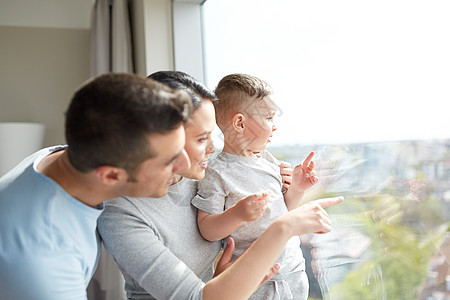 人们家庭的快乐的母亲,父亲小儿子透过窗户看着家里幸福的家庭透过窗户看着家里图片